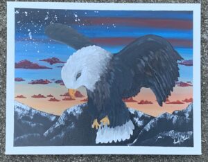 A drawing of a bald eagle in front of mountains and a sunset
