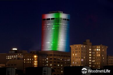 WoodmenLife Tower lit in red, white, blue, and green.