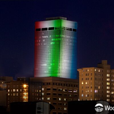 WoodmenLife Tower lit in red, white, blue, and green.