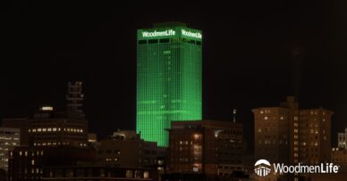 WoodmenLife Tower lit in green