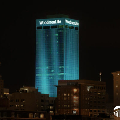 WoodmenLife Tower lit in teal